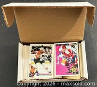 Open cardboard box showing large stack of trading cards