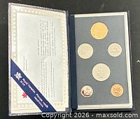 Open display case showing certificate and six coins