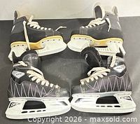 Two pairs of CCM hockey skates, side view showing uppers, holders, blades