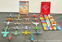 Group shot of die-cast planes, die-cast cars and two DVD cases
