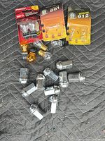Group shot of sealed bulb packs, loose bulbs, and lug nuts