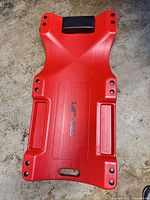 Top view showing red plastic creeper with black headrest and Pro-Lift logo