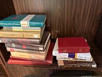 Books stacked on shelf showing range of titles and bindings