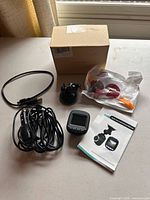 All items laid out: dash cam, suction mount, power cord, USB cable, accessory bag, manual, box