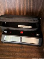 Front view of digital chess clock and carrying pouch