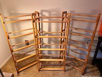 Front view of three wood media racks showing overall structure and shelf tiers