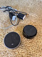 Two Echo Dot speakers and power adapters on carpet