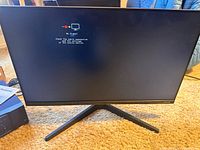 Front view of Samsung 24-inch monitor powered on showing "No Signal" screen