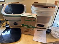 Two collapsible washers with lids, three detergent boxes, accessories