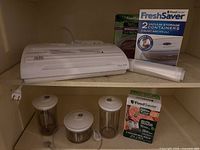 Overall lot showing sealer, boxed containers, bag roll, loose canisters