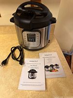 Full view of Instant Pot IP-DUO with power cord and manuals on countertop