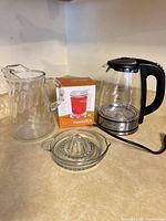 Group shot showing pitcher, IngenuiTEA box, electric kettle, glass juicer
