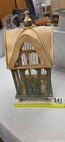 Full view of wooden decorative bird cage with measuring tape showing height