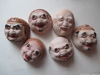 Six intact mask cups showing painted faces