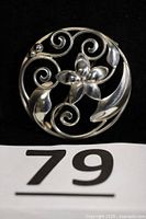 Front view of round sterling floral brooch showing design