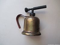 Side view showing entire Dunlap brass blowtorch with red handle and burner tube