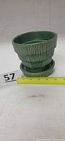Full view of green McCoy basket weave flowerpot with saucer next to scale ruler