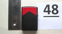 Front view of lighter closed beside ruler showing scale