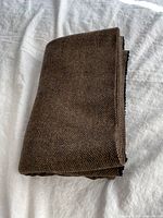 Folded brown tweed fabric showing texture