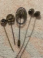 All five stick pins laid out on fabric background