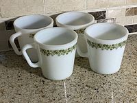 Front view of all four Pyrex Spring Blossom mugs