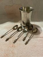 Overall view of pewter tumbler with five spoons