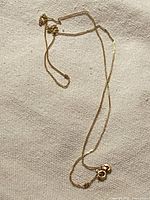 Full length view of box chain necklace laid out on fabric