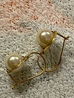 Both earrings showing gold wire drop and pearl detail