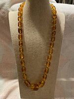 Full view of the amber bead necklace on display form