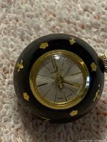 Front view showing dial signed HENO, Swiss Made, enamel body and gold decals