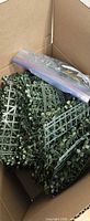 open box showing stacked plastic mesh greenery panels with zip bag of connectors
