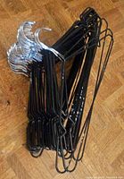 Stack of black metal wire hangers showing coating and chrome hooks
