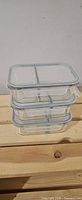 Stacked view of three rectangular glass containers with lids