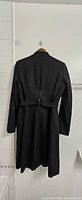 Back view of black Calvin Klein trench coat with belt attached, hung on hanger