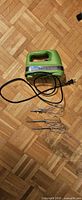 Green Cuisinart hand mixer with cord, two beaters and two dough hooks on parquet floor
