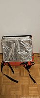 Backpack opened showing silver foil insulation and shoulder straps