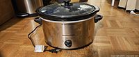 Front view of Hamilton Beach stainless steel slow cooker with lid and power cord