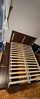 Overall view of disassembled full platform bed frame with slatted base and storage drawers