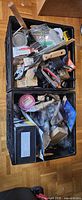 Overall view of two crates filled with mixed hand tools and hardware