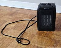 Front view of black space heater showing controls and power cord