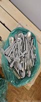 Bag filled with assorted stainless steel flatware pieces