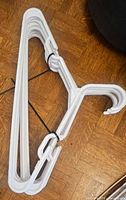 Bundle of white plastic adult clothes hangers tied together