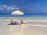 close view of beach scene showing chairs and umbrella