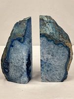 Front view of both blue agate geode bookends showing polished faces and crystal interiors