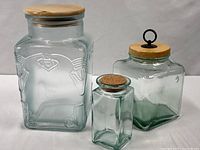 All three glass canisters with respective lids