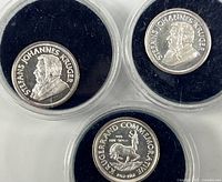 Three silver rounds in capsules showing obverse and reverse