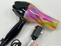 Full view of hair dryer showing multicolor barrel, black handle and attached cord