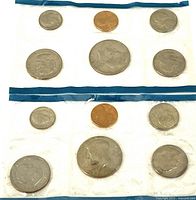 Two sealed coin set sleeves showing 1979 and 1980 coins