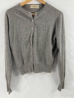 Front view of light gray cashmere cardigan on hanger