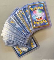Stack of Pokémon cards in rigid sleeves showing backs